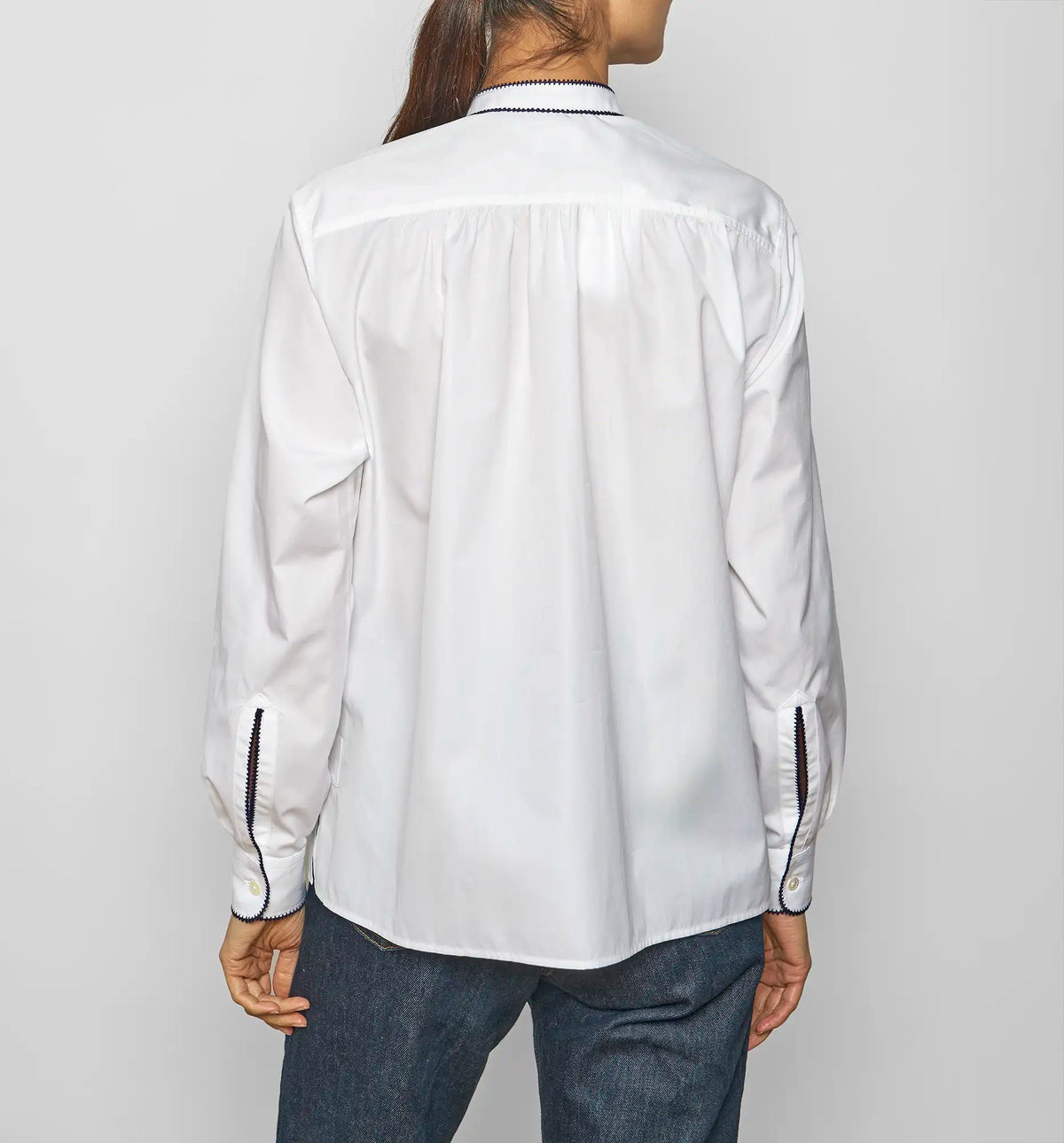 Model wearing a white cotton poplin pullover shirt by Sébline, back view.