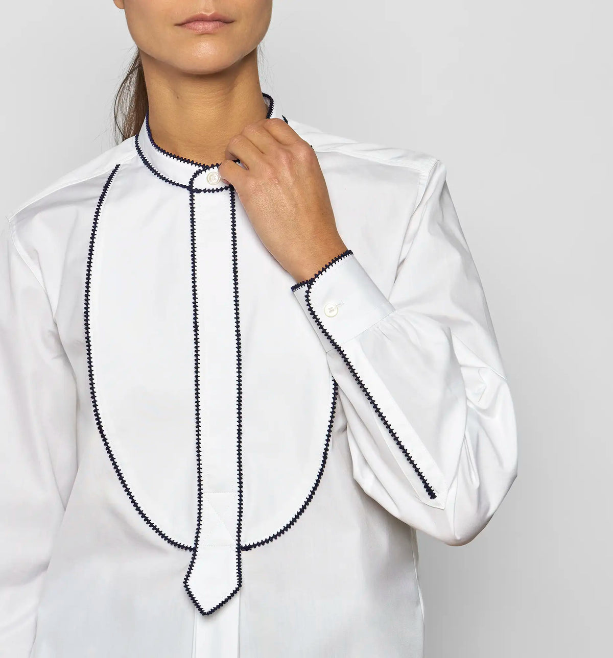 Detail of gathered cuffs with button closure on a white cotton poplin shirt by Sébline.