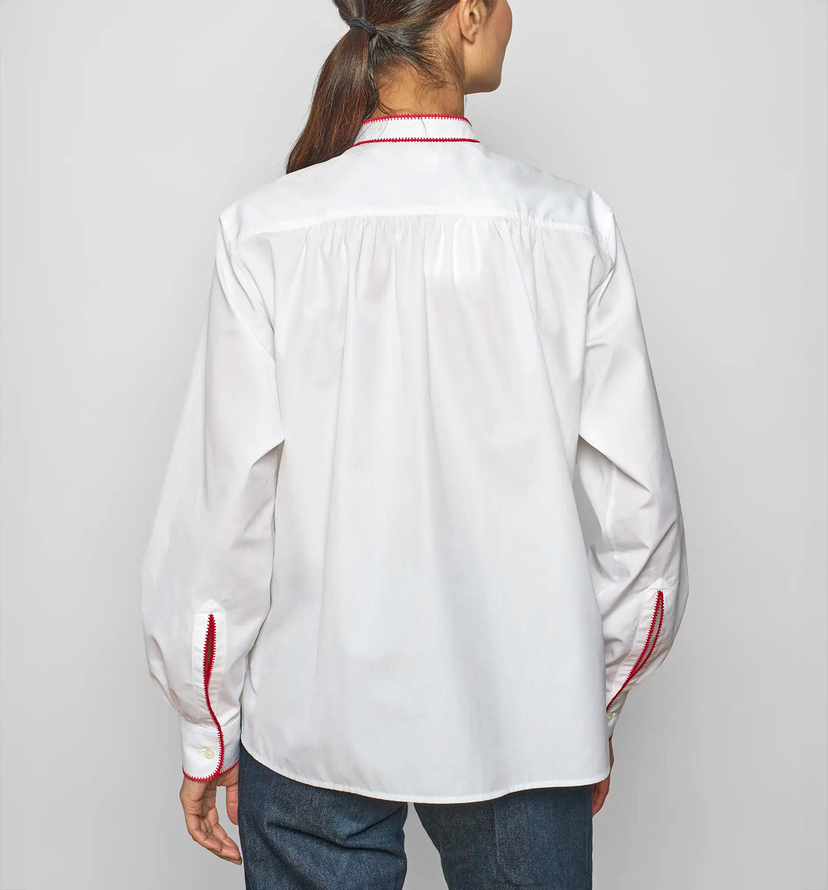 Model wearing a white cotton poplin pullover shirt by Sébline, back view.