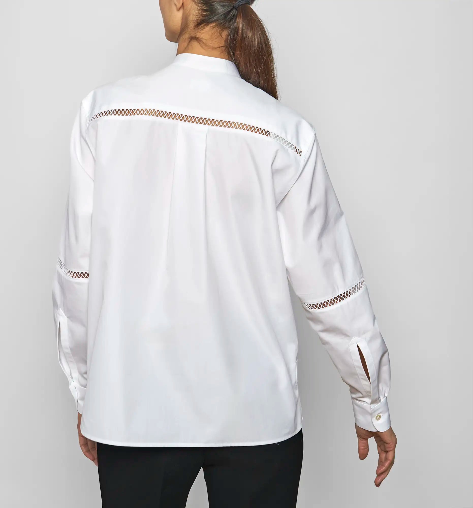 Back view of a model wearing the white Venetian Painter’s Shirt by Sébline, showing the back pleat and gathered cuffs.