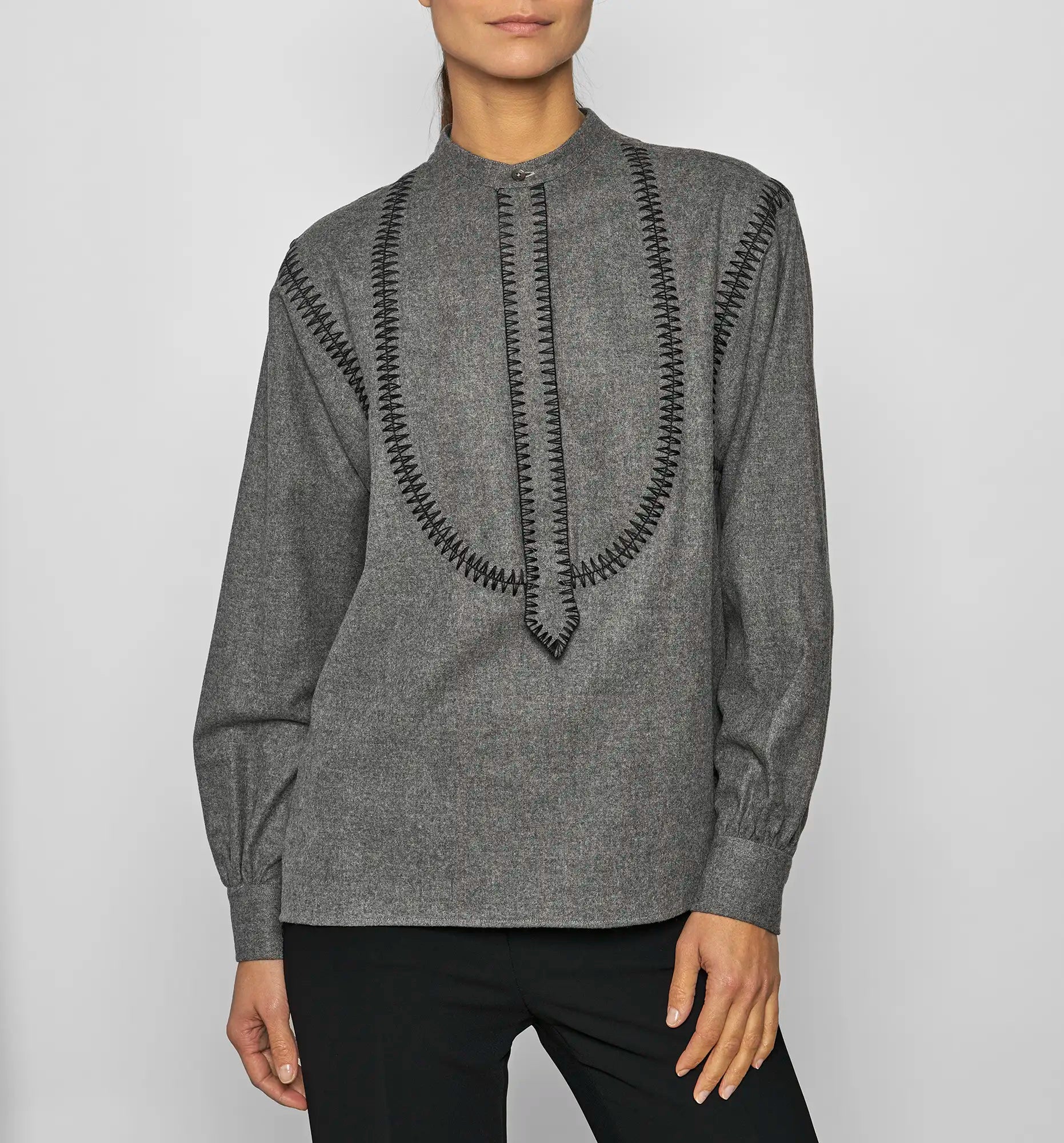 Front view of a model wearing a charcoal Sébline pullover shirt with black embroidered detailing.