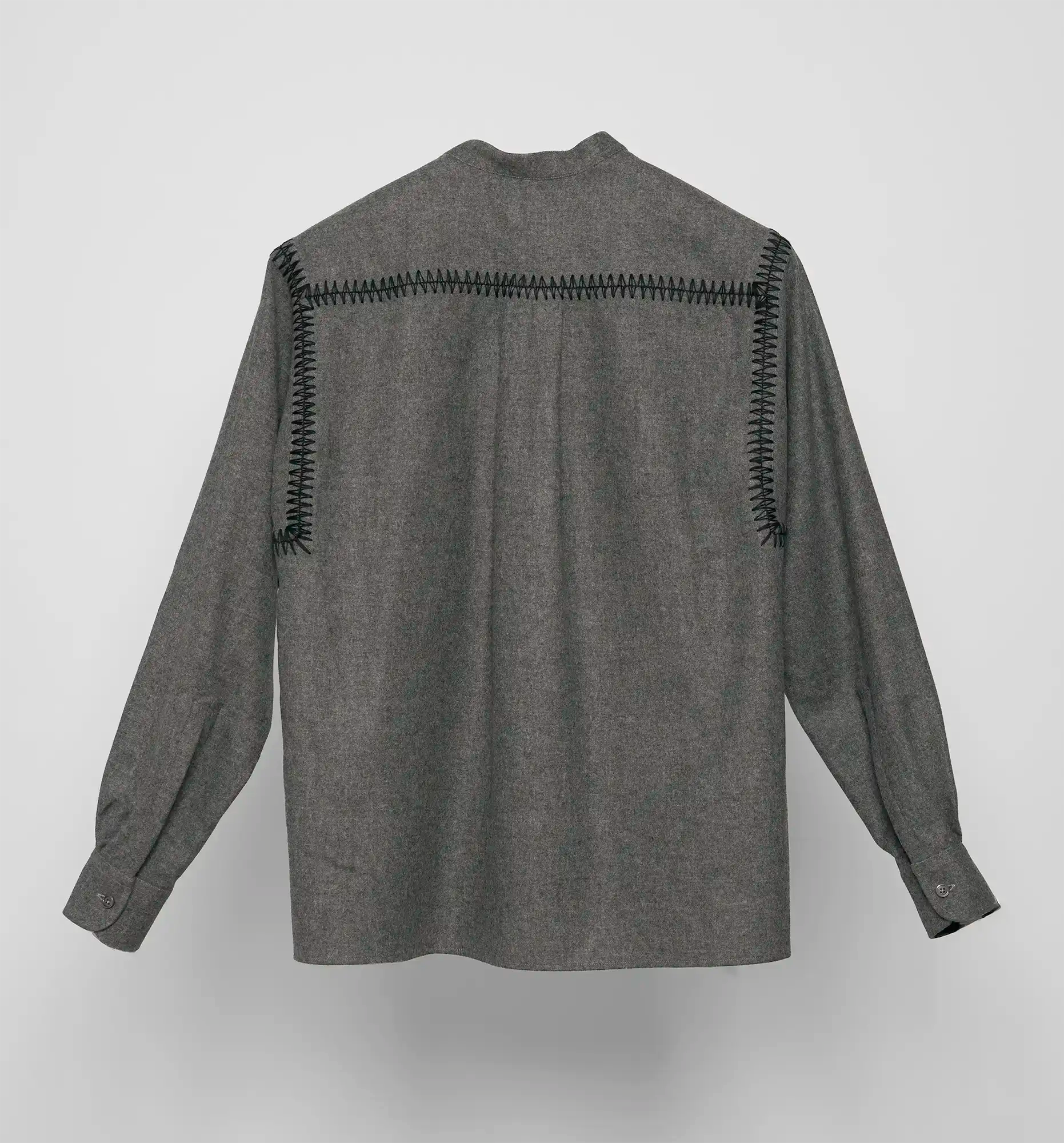 Back view of a charcoal Sébline pullover shirt with black embroidered detailing on a light grey background.