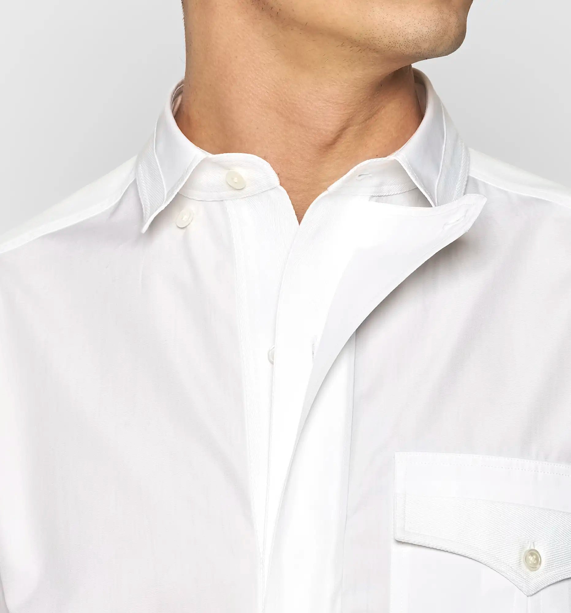 Detail view of the collar of a white Sébline shirt worn by a model