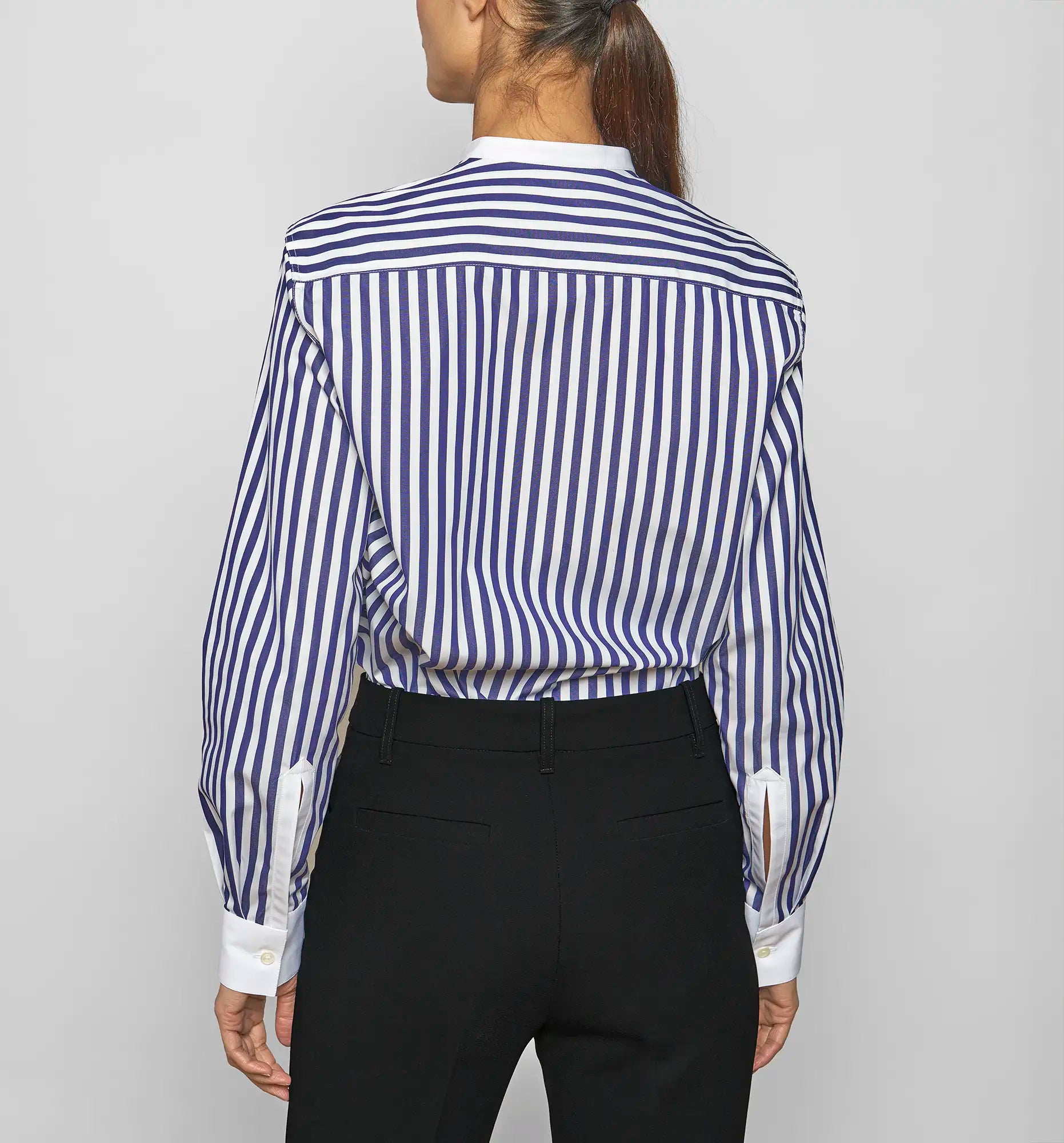 Model wearing a Sébline navy-and-white striped long-sleeve shirt, back view.