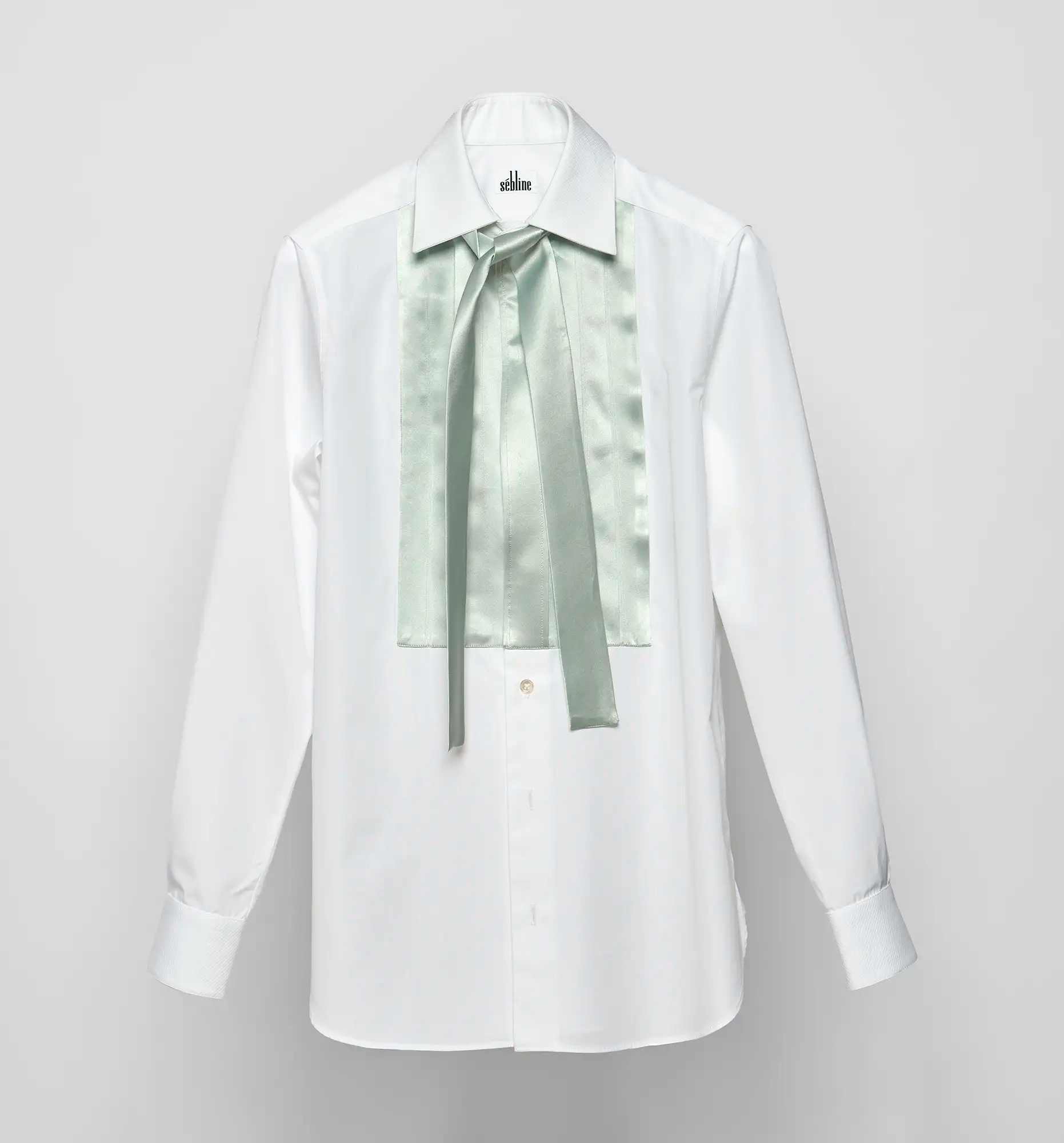 Sébline white shirt laid flat with mint green satin pleated bib and matching neck bow.