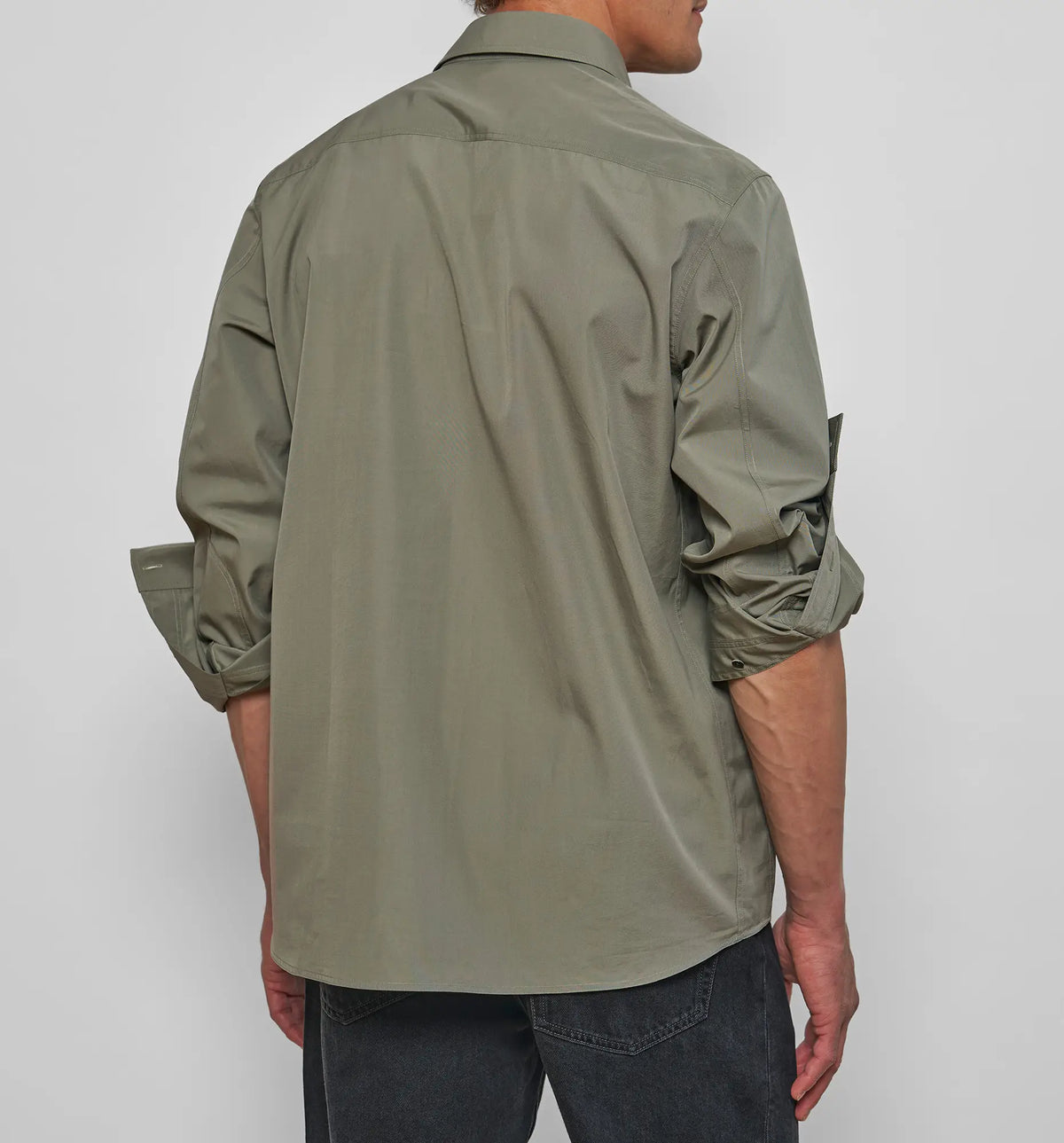 Combat Polo Shirt – Model wearing the khaki asymmetric pullover shirt, side view