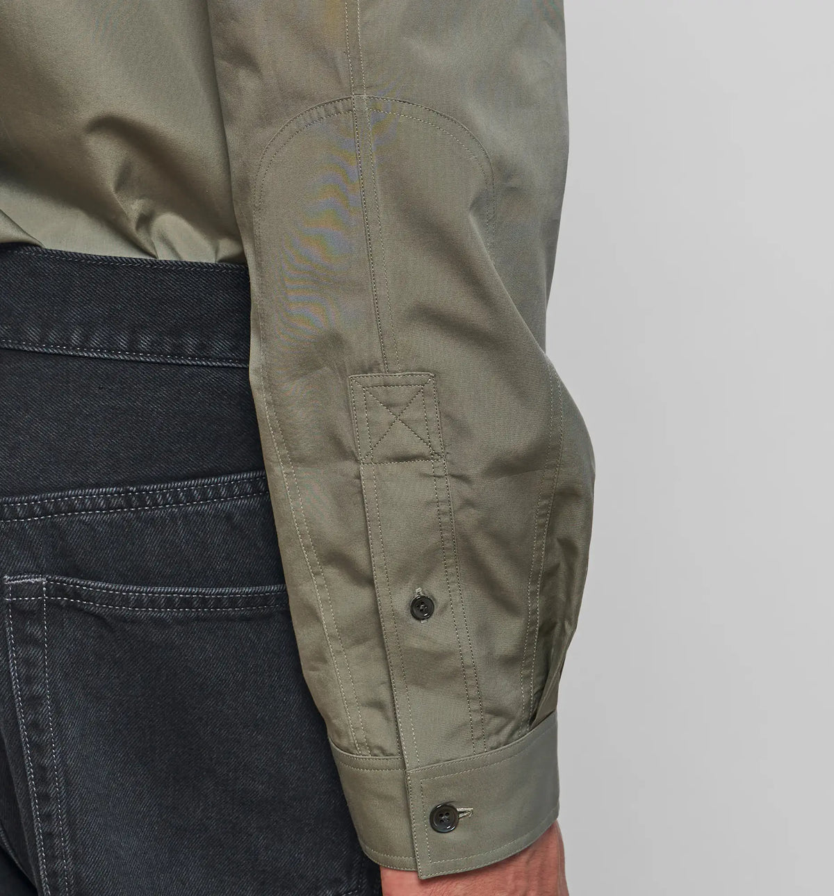 Combat Polo Shirt – Detail of the cuff and side vent on the khaki pullover shirt, flat lay