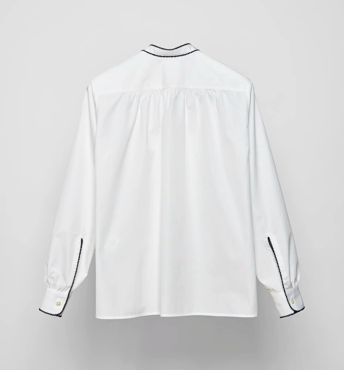 White cotton poplin pullover shirt by Sébline, back view on neutral background.