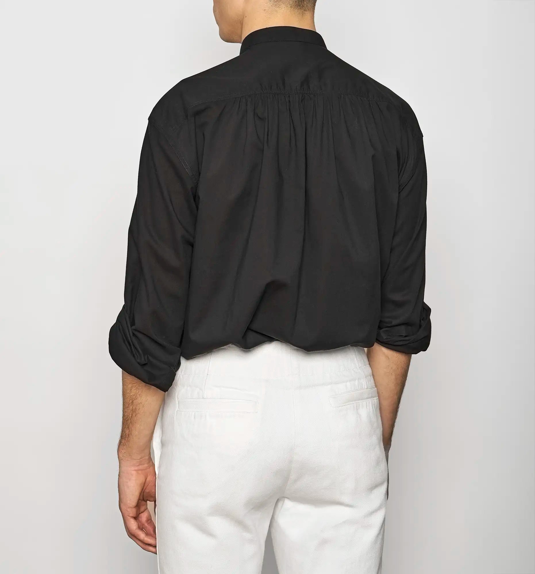 Back view of a black Sébline pullover shirt worn by a model