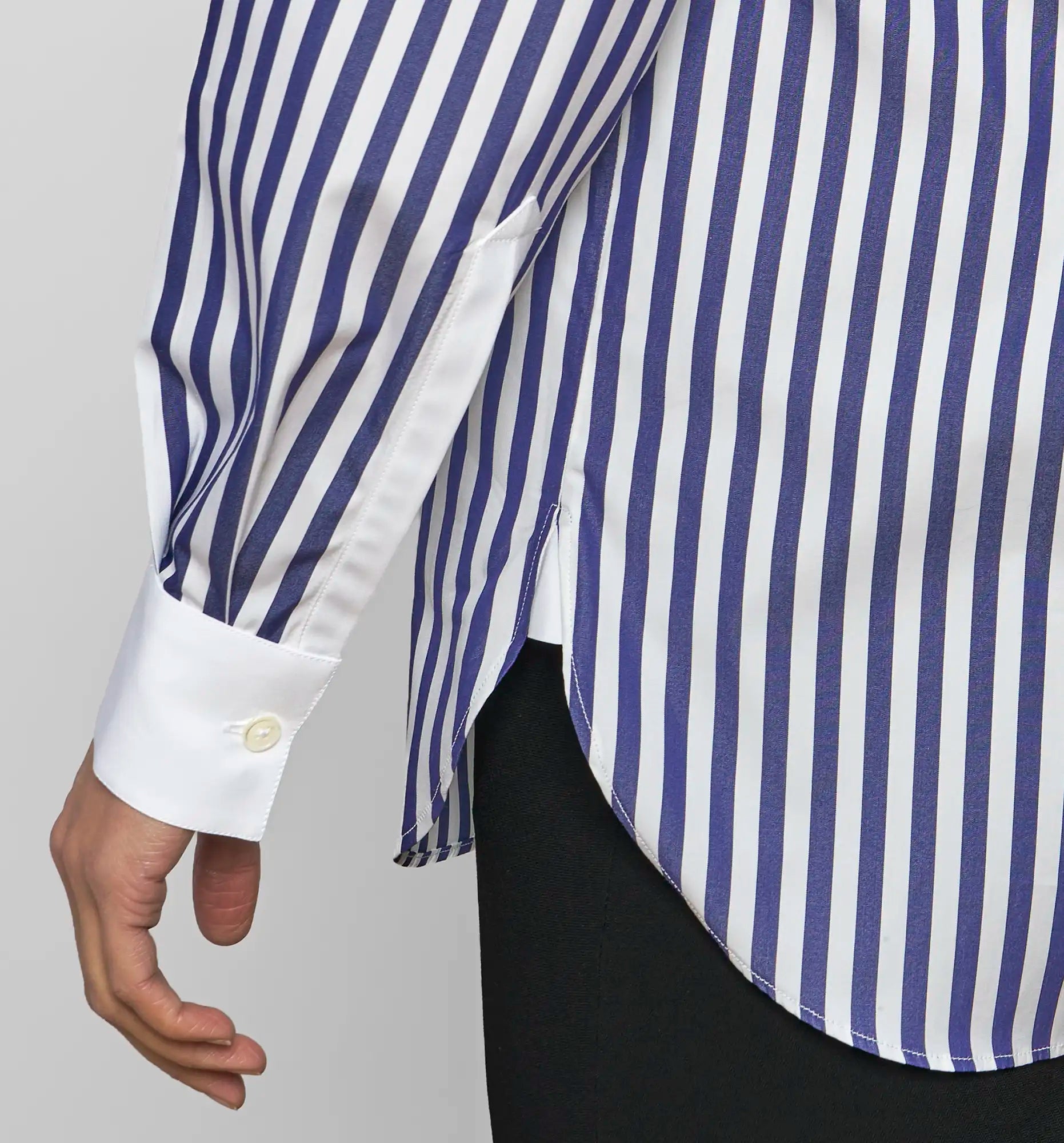 Close-up of a Sébline navy-and-white striped shirt showing the curved side hem.