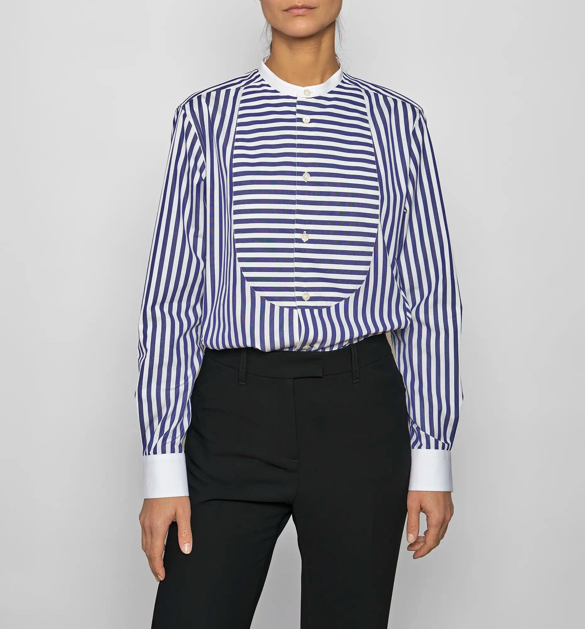 Model wearing a Sébline navy-and-white striped long-sleeve shirt with striped bib, front view with shirt tucked into trousers.