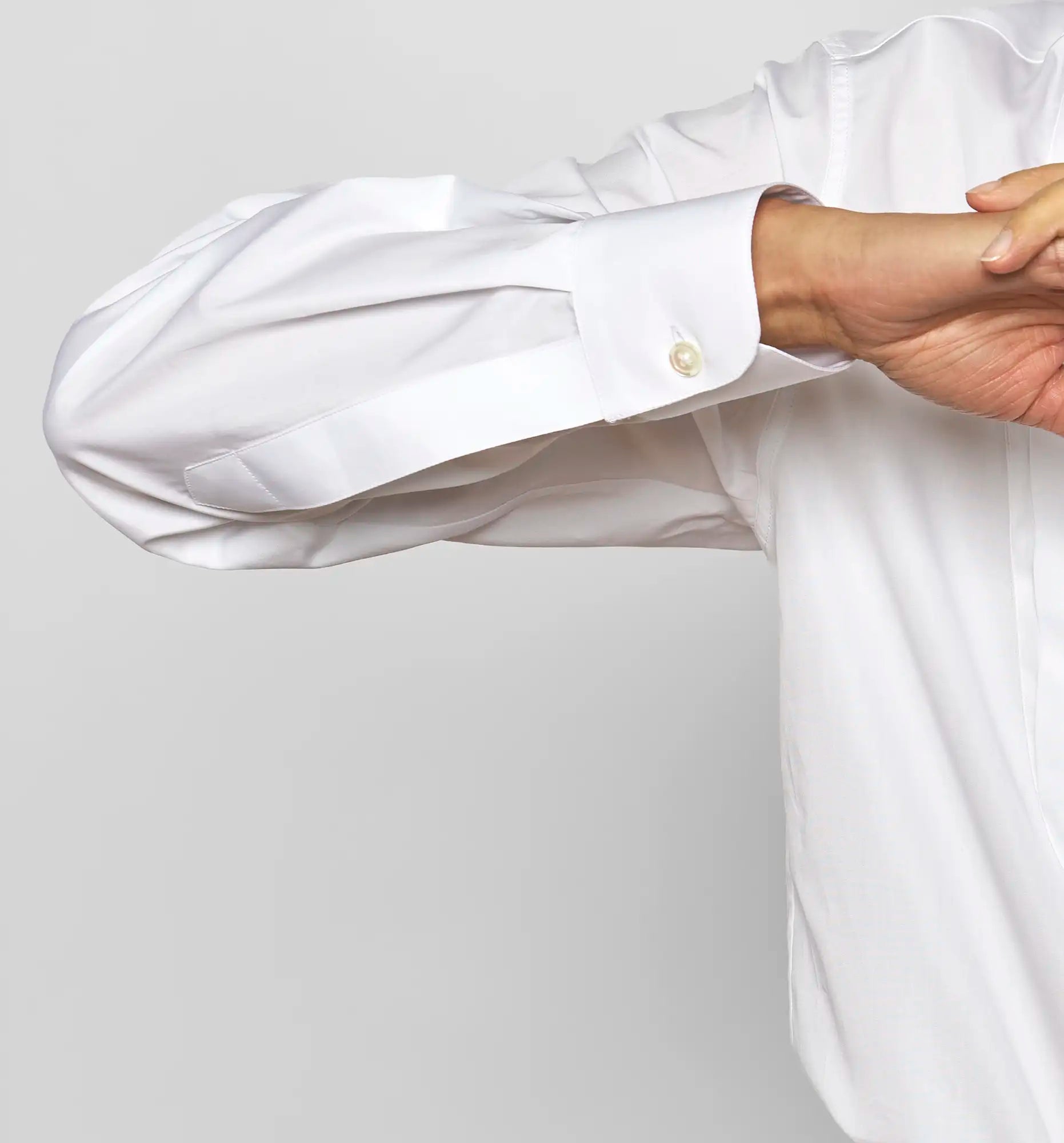 Close-up of a Sébline white shirt cuff with buttons.