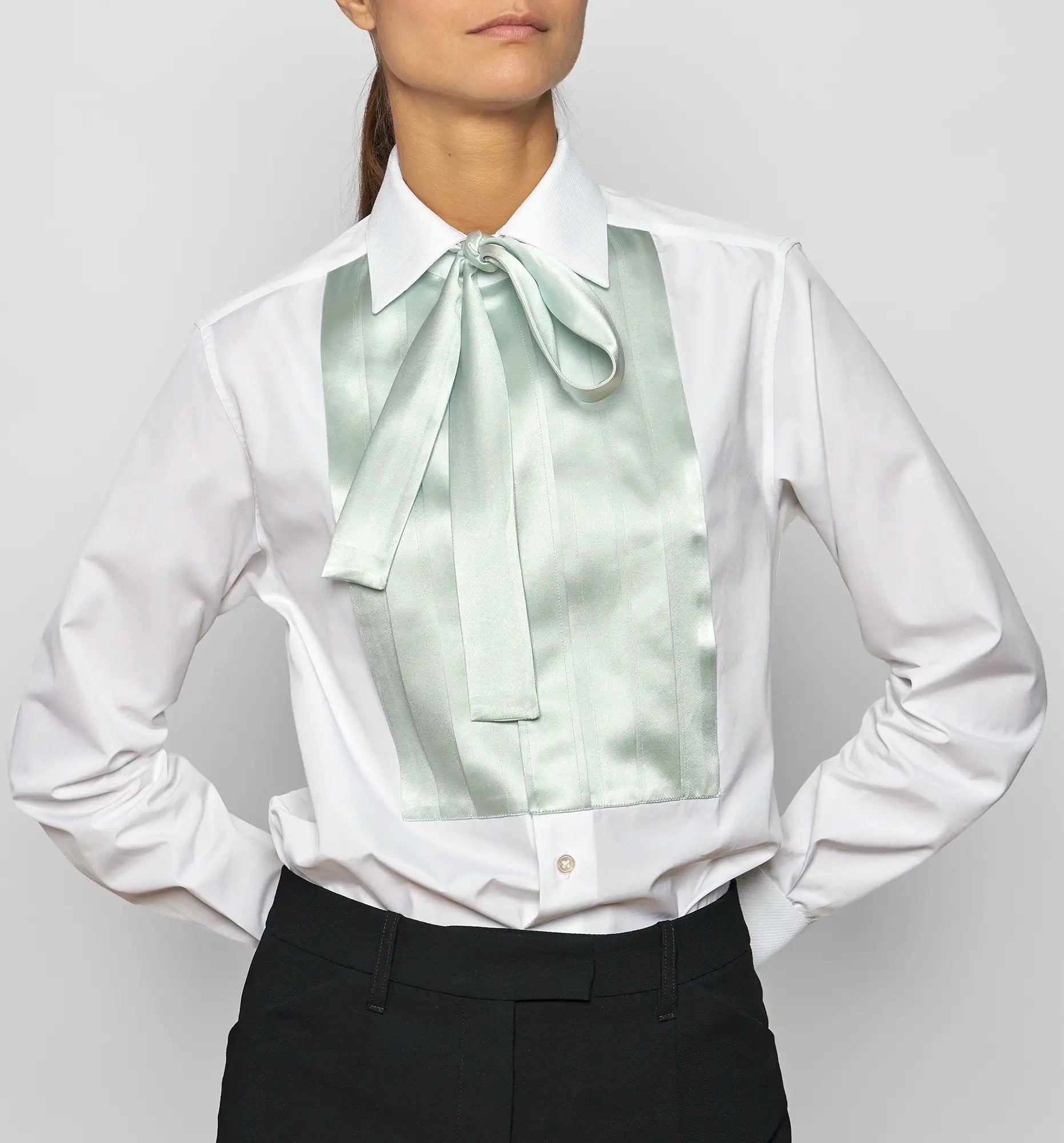 Model wearing Sébline white shirt with mint green pleated bib and neck bow, front view.