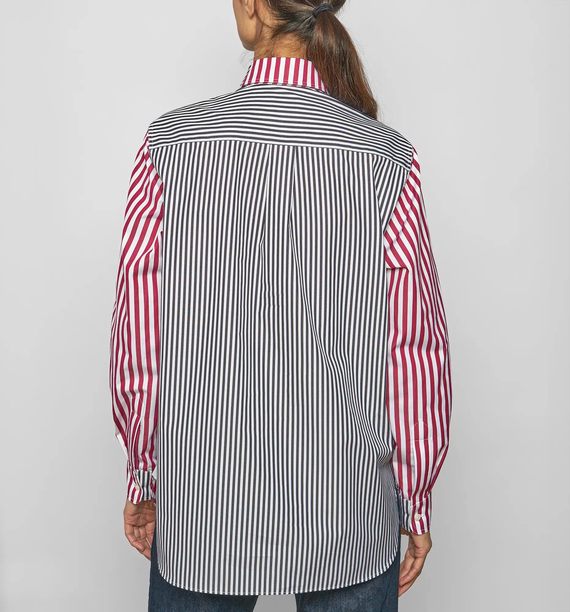 Model wearing Sébline patchwork striped cotton poplin shirt, back view.