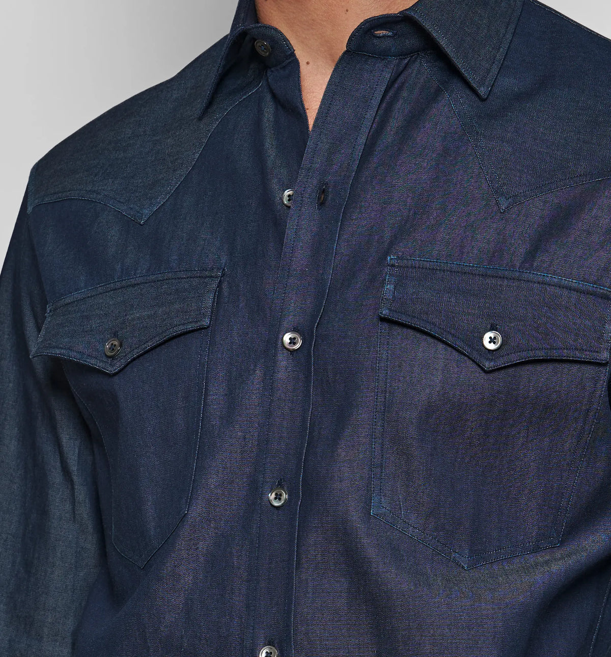 Chemise Cowboy – Close-up of the chest pockets and stitching on the denim shirt, worn