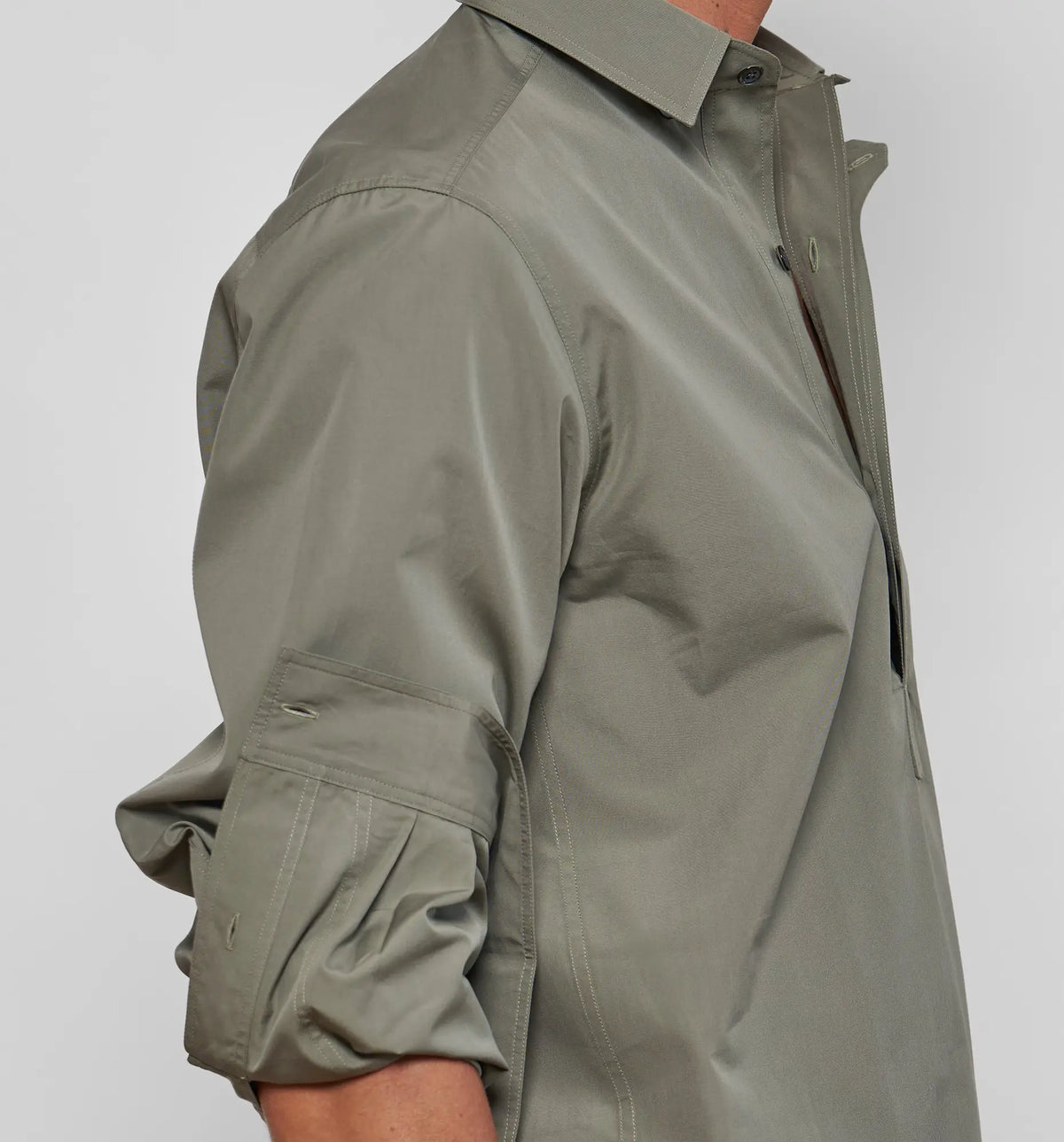 Combat Polo Shirt – Close-up of the sleeve on the khaki pullover shirt, worn